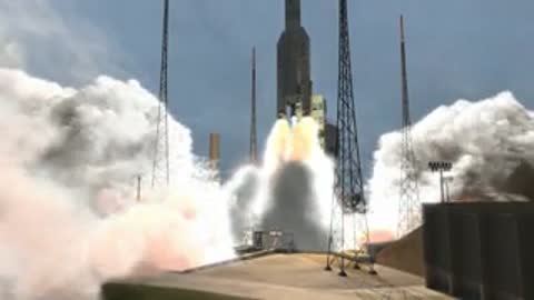 Wide shot of the rocket lifting off from the pad amidst a cloud of smoke