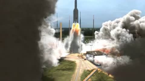 Medium shot of the rocket ascending through dense exhaust smoke
