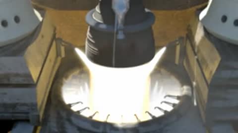 Close-up view of the rocket engine igniting at the base of the pad