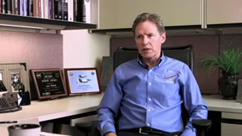 A man sitting in an office chair speaking during an interview.