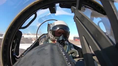 Pilot sitting inside the cockpit of a parked aircraft.