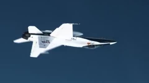 White jet flying against a clear blue sky background.