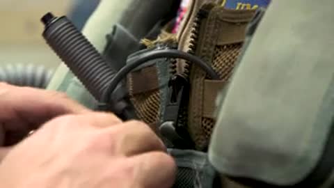 Close up of hands handling helmet and equipment on table.