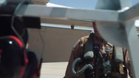 Pilot walking near aircraft on tarmac.