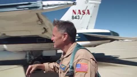 Pilot checking aircraft wing on tarmac.