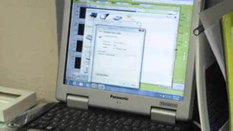 Laptop screen showing interface followed by man talking.