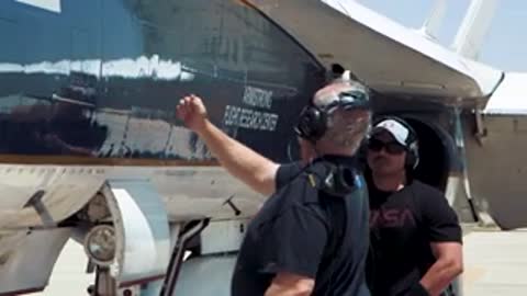 Crew members preparing aircraft on tarmac.