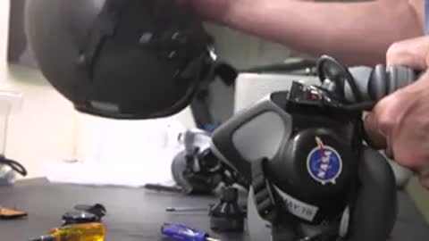 Hands adjusting oxygen mask and helmet equipment.