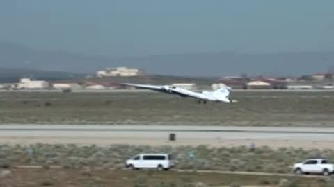 X-59 aircraft taking off from runway into clear blue sky.