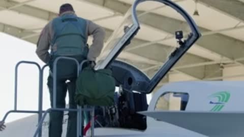 NASA test pilot climbing ladder and entering X-59 cockpit.