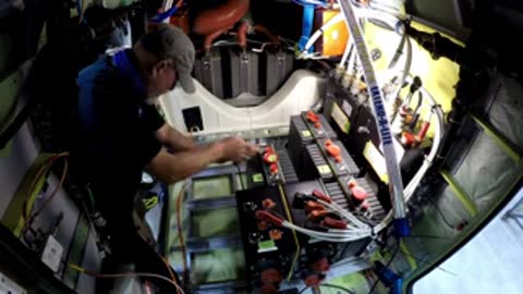 Technician working on internal electrical components of an aircraft in the hangar