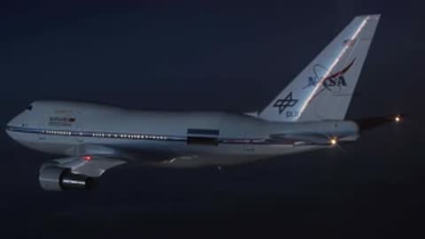 Complex scientific instrument inside the SOFIA aircraft followed by aircraft in flight.