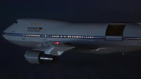 A NASA SOFIA Boeing 747 aircraft in flight at night with its cargo door open.