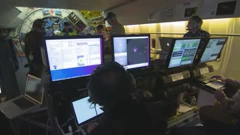 Control room interior with multiple monitors and personnel monitoring SOFIA operations.
