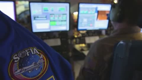 Close-up of a computer monitor and a crew member's jacket with a SOFIA patch.