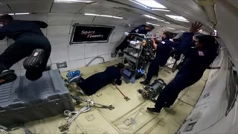 Astronauts floating inside a cabin during a zero-gravity flight experience.