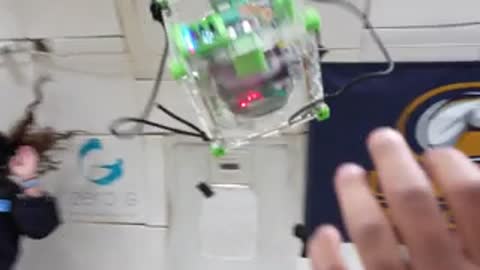A cube satellite floating inside a cabin during zero-gravity experiments.