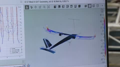 Computer monitor displaying 3D aircraft wireframe and simulation data