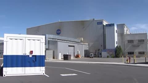 Exterior shot of a facility building with a white and blue container in front