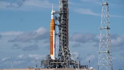 Static view of the Space Launch System on the launch pad by day.