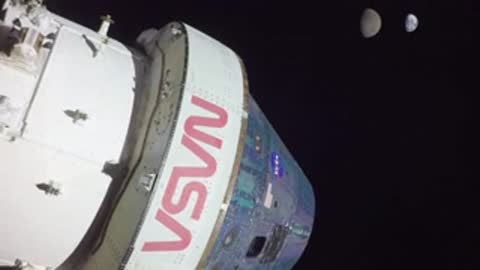 View of the Orion spacecraft in space with the Moon in the background.