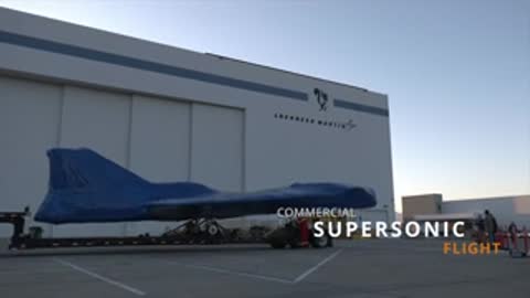 Covered aircraft being transported outside a large hangar building