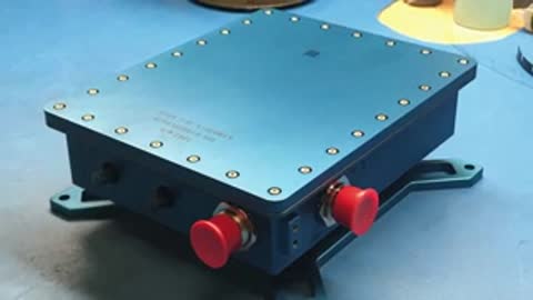 A closed blue electronic device housing on a workbench.