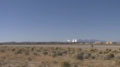 Jet aircraft taking off from a runway into a clear blue sky.