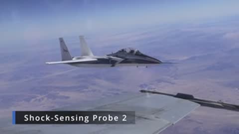 Jet aircraft flying near a trailing probe sensor labeled Shock-Sensing Probe 2.