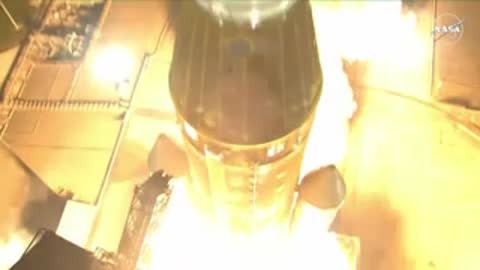 Rocket launch viewed from above with fiery exhaust and smoke