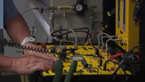 Close-up of laboratory testing equipment and wires connected to a panel.