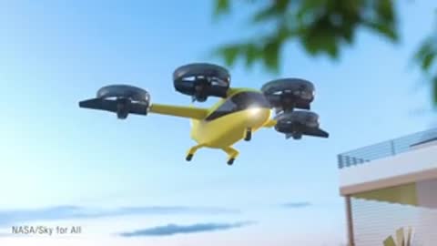 Yellow multi-rotor electric aircraft hovering near a building rooftop in an urban area.