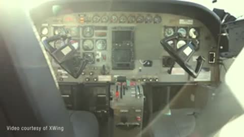Cockpit view from inside a small aircraft looking out over the dashboard controls.