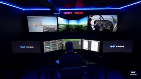 Operator sitting at a control desk with multiple monitors displaying aircraft feeds.