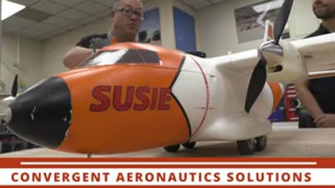 Nose cone of a test aircraft labeled SUSIE during assembly in a hangar.