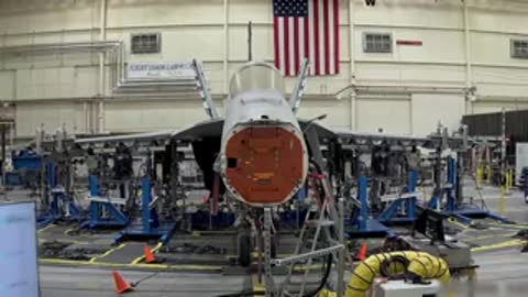 Front view of an aircraft nose section positioned inside a structural test laboratory facility.