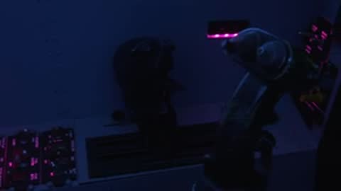Close-up view of flight simulator controls and instrumentation panel illuminated in blue light.