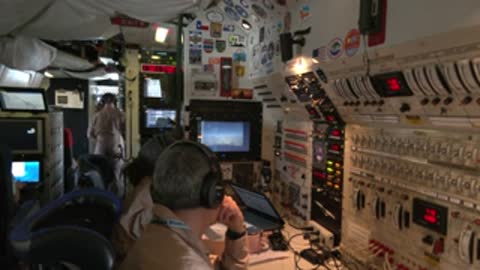 Control room operators monitoring equipment displays and communicating during a flight test operation.