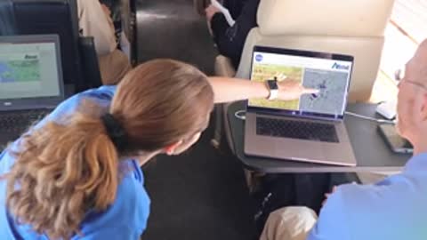 A person points at a laptop screen showing scientific data.