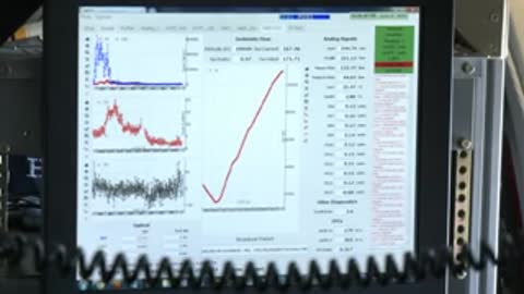A computer screen displays scientific graphs and data lines.