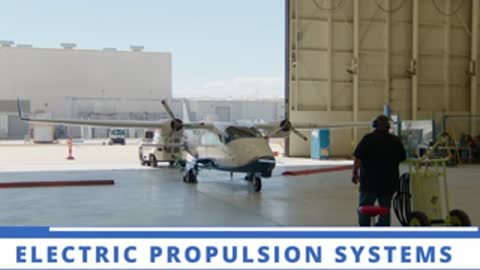 Electric propulsion systems aircraft inside a hangar with a person walking past