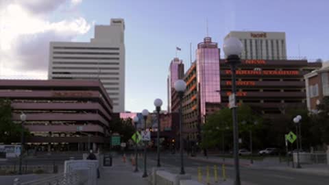 City street view with buildings under a partly cloudy sky.