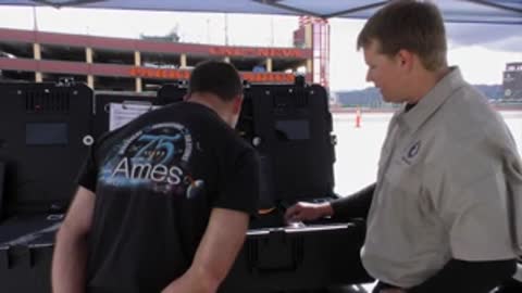 Two men working at a case outdoors near building.