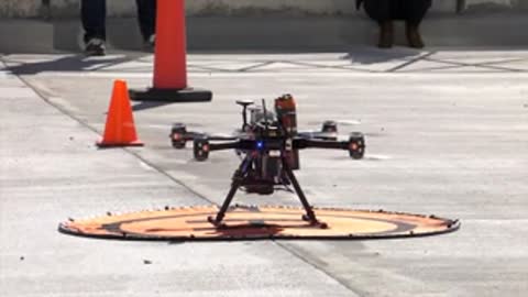 Close-up of a drone on a landing pad with cones.