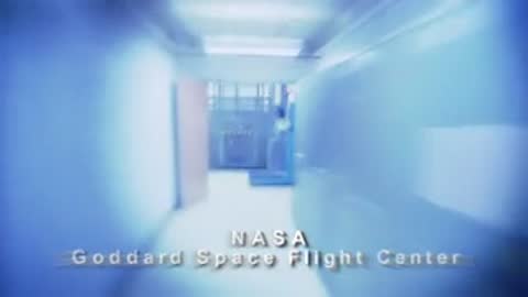 Rapid tracking shot moving through a white corridor with facility text overlay