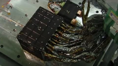 Close-up of complex electrical wiring and wrapped components on a spacecraft part