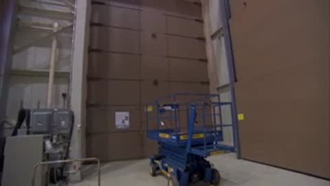 Control room staff watching a testing procedure through a large window