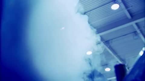 Smoke billowing inside a brightly lit industrial cleanroom facility