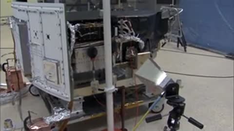 Antenna positioned near a piece of spacecraft hardware in a lab