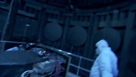 A medium view of an engineer inspecting electronic components inside the facility.